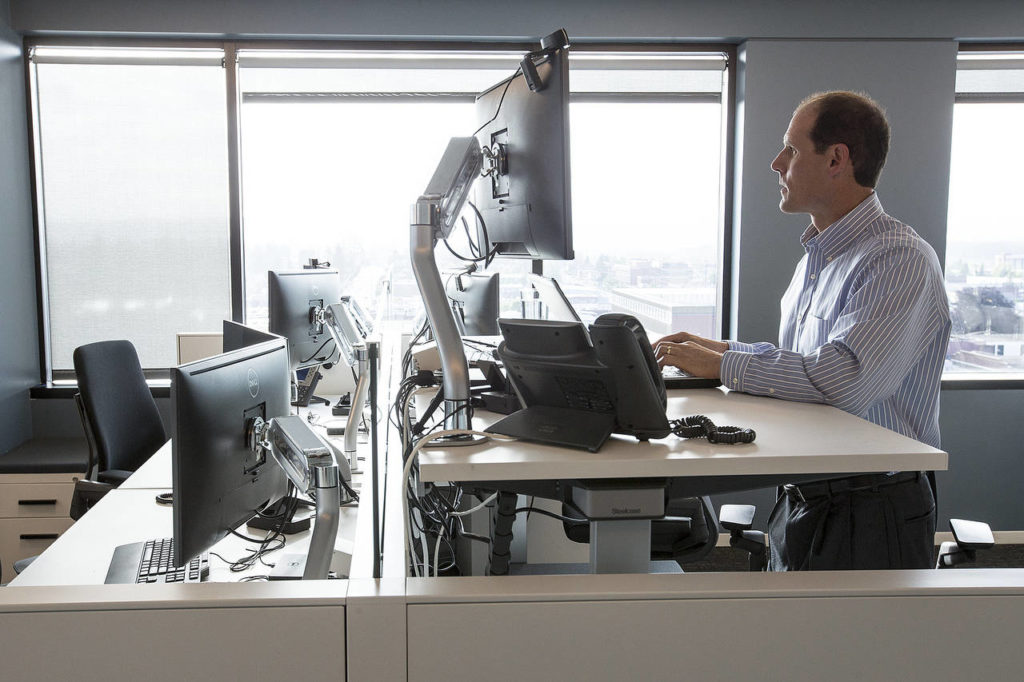 A recent remodel at Everett’s Moss Adams offices included installing adjustable desks to replace old cubicles. (Ian Terry / The Herald)
