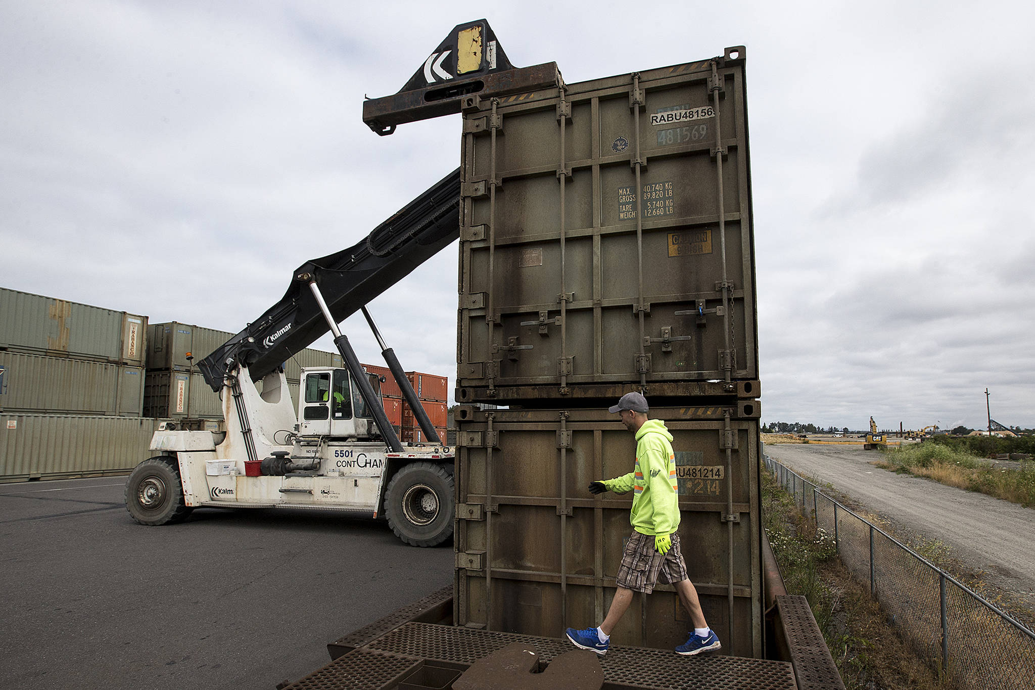 Justin Hottel inspects the locks on containers after they were loaded on to a train bound for Eastern Washington in Everett on Tuesday. (Ian Terry / The Herald)