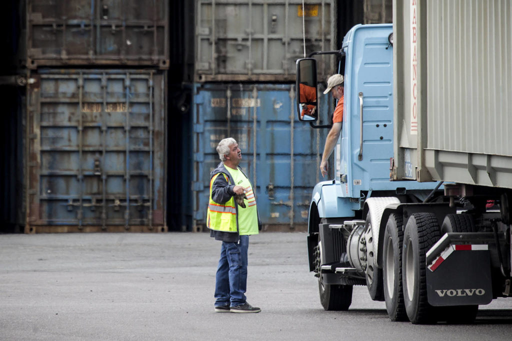 Truck drivers prepare to drop their containers of compacted garbage onto trains in Everett on Tuesday. (Ian Terry / The Herald)
