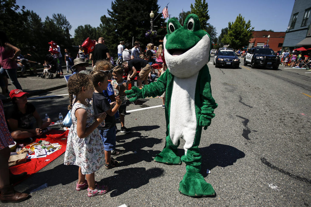 A Kla Ha Ya Days frog gives out high-fives to young parade attendees. (Ian Terry / The Herald)
