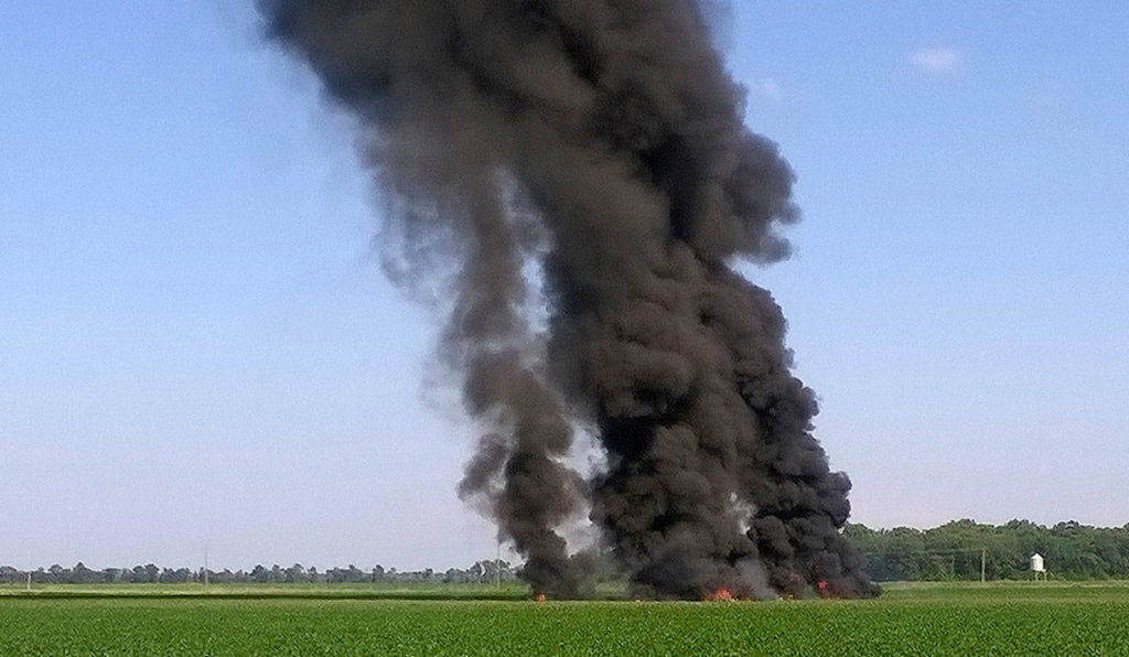 Smoke and flames rise after a military transport airplane crashed in a field near Itta Bena, Mississippi, on Monday. (Jimmy Taylor via AP) 
