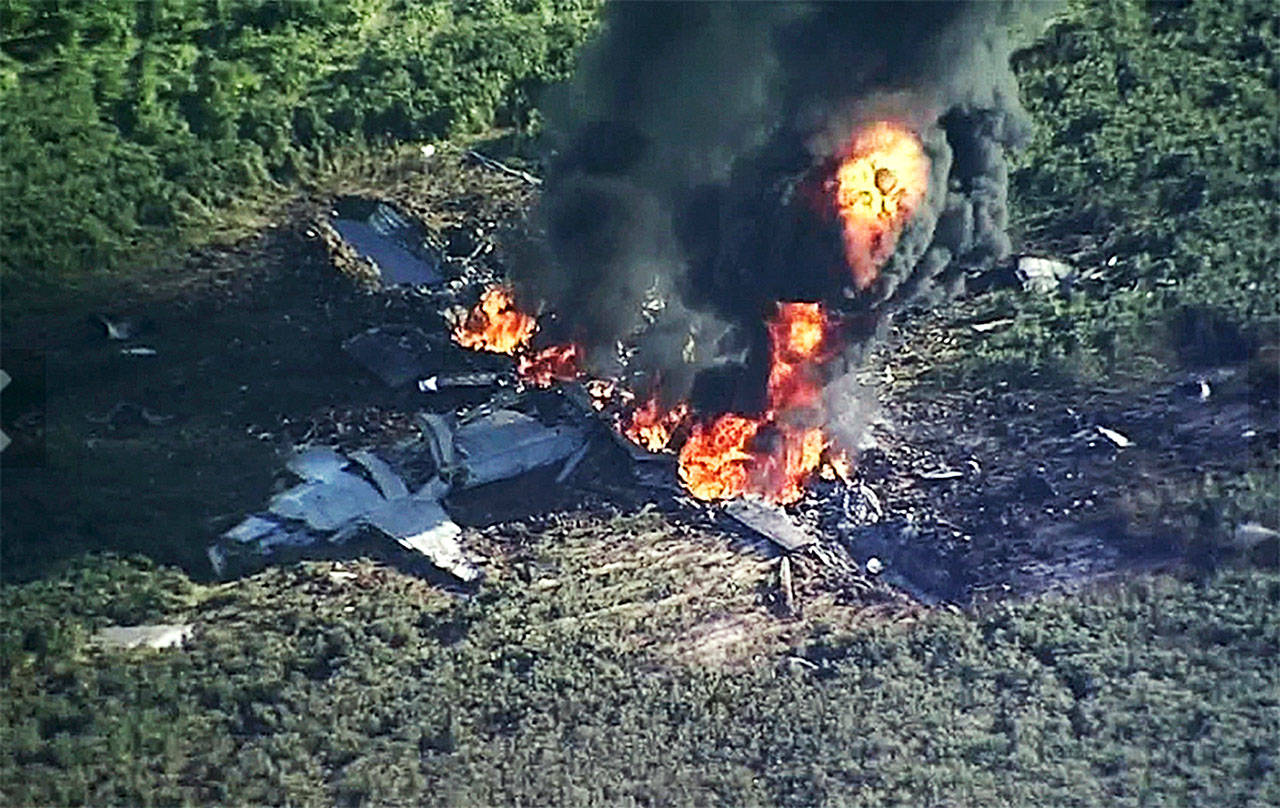 In this Monday frame from video, smoke and flames rise from a military plane that crashed in a farm field, in Itta Bena, Mississippi., killing several. (WLBT-TV via AP)