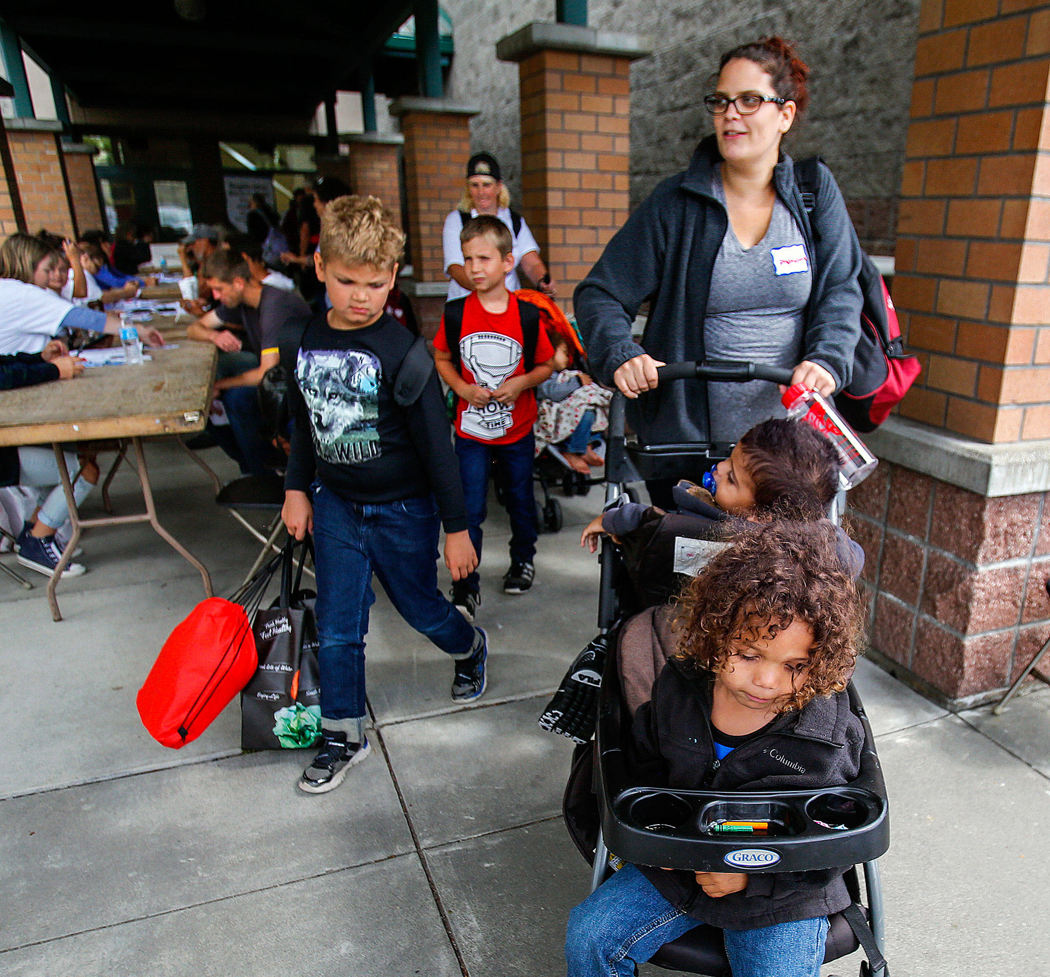 After a successful visit and lunch, Shakarra Borchgrevink leaves Project Homeless Connect 2017 with her four children, ages 1-7, her little brother and her mom Thursday. Just a year ago, Borchgrevink was homeless, yet was able to change that with help she found at Project Homeless Connect. (Dan Bates / The Herald)