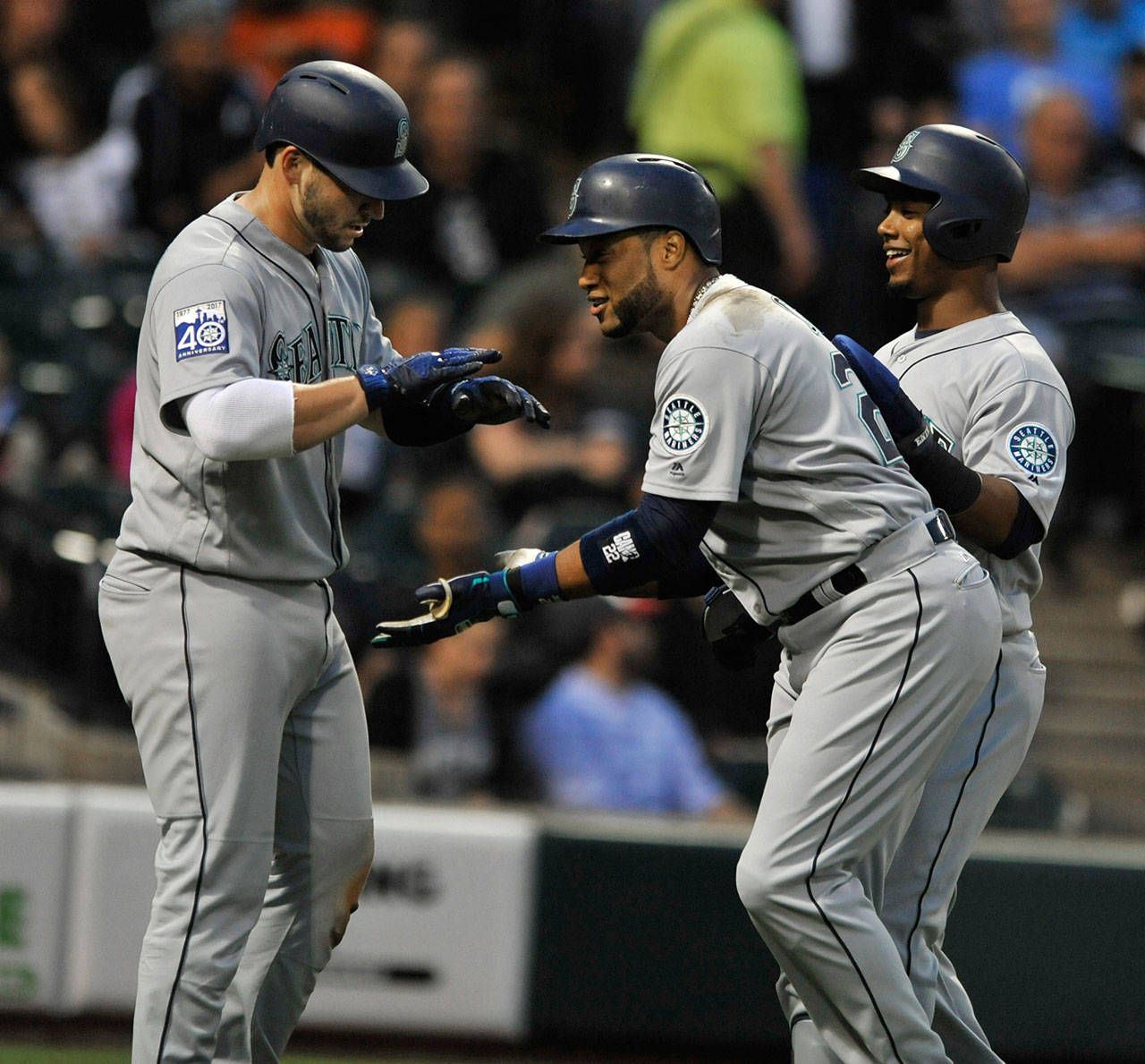 Seattle’s Robinson Cano (center) celebrates with teammates Jean Segura (right) and Mike Zunino after hitting a three-run home run in the third inning of Friday’s game in Chicago. (AP Photo/Paul Beaty)