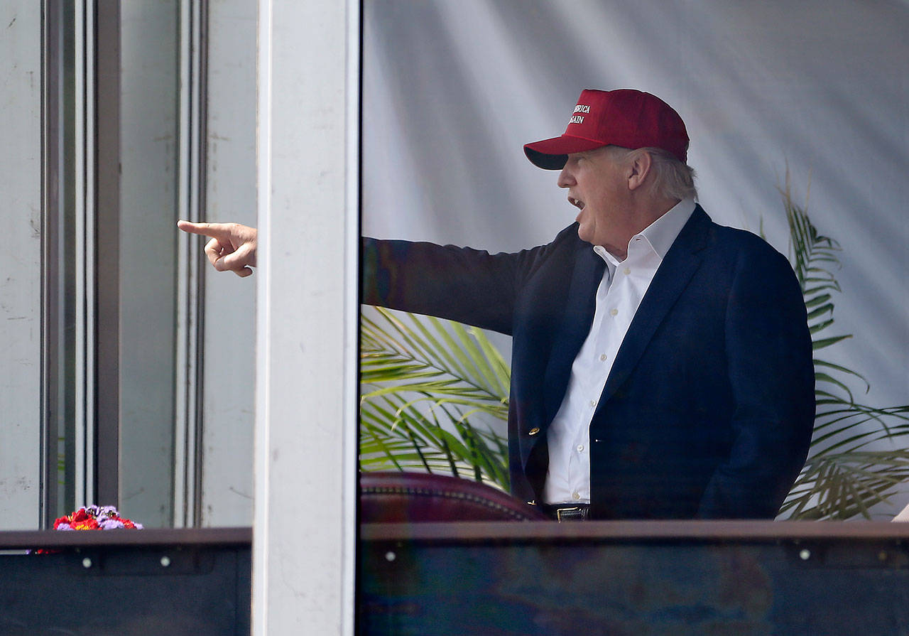 President Donald Trump reacts to spectators as he watches the third round of the U.S. Women’s Open Golf tournament from his observation booth Saturday in Bedminster, New Jersey. (AP Photo/Seth Wenig)