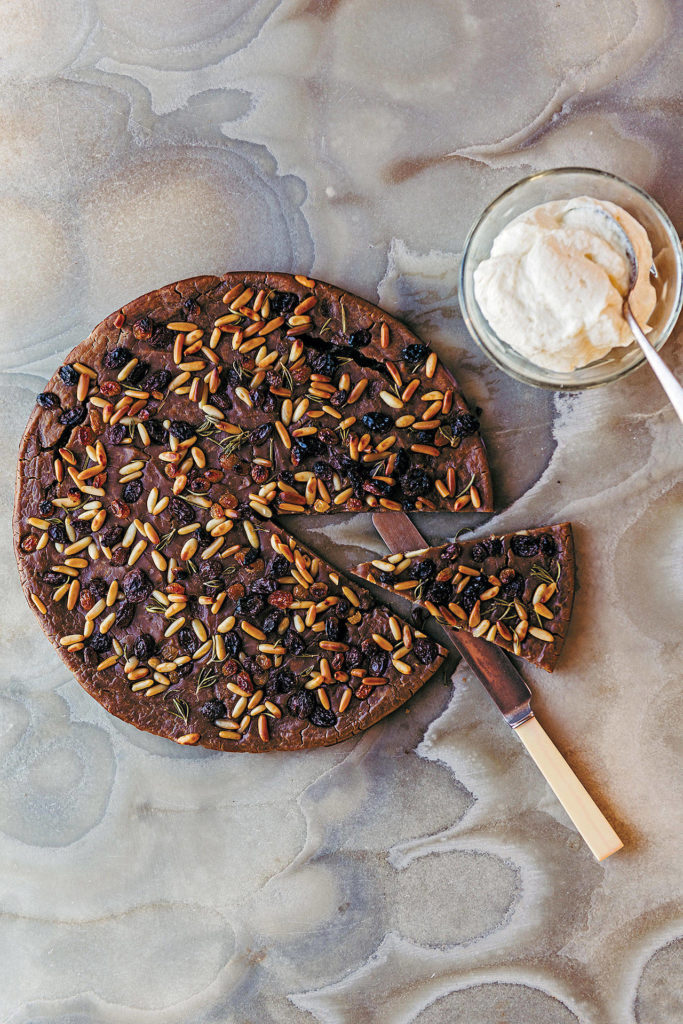 Castagnaccio is a chestnut flour cake with pine nuts and golden raisins. When serving a slice, top it with a dollop of ricotta cream. (Photo by Lauren Bamford)
