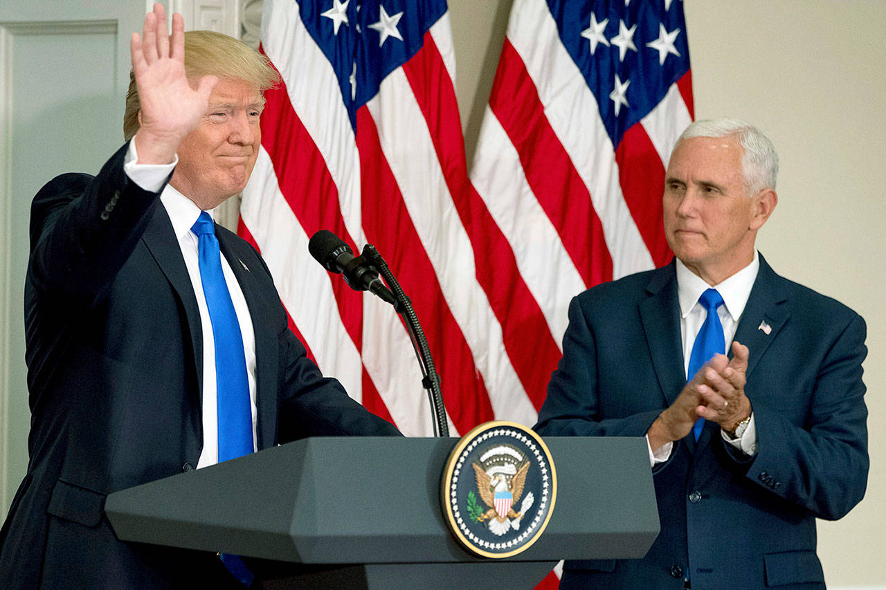 President Donald Trump, accompanied by Vice President Mike Pence, waves after speaking during the first meeting of the Presidential Advisory Commission on Election Integrity at the Eisenhower Executive Office Building on the White House complex in Washington on Wednesday. (AP Photo/Andrew Harnik)