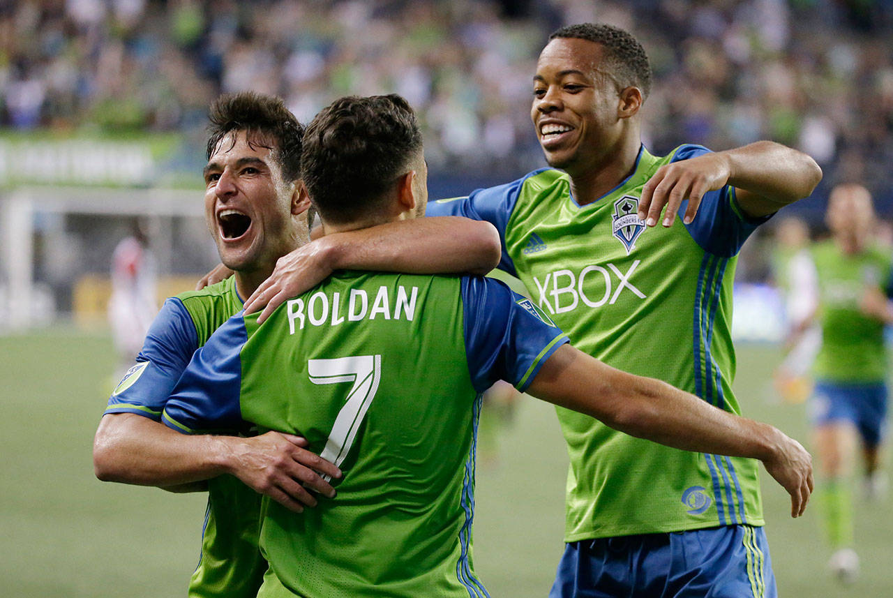 Sounders midfielder Cristian Roldan (7) celebrates with Nicolas Lodeiro (left) and Jordy Delem after Roldan scored a goal against D.C. United during the second half of an MLS match on July 19, 2017, in Seattle. (AP Photo/Ted S. Warren)