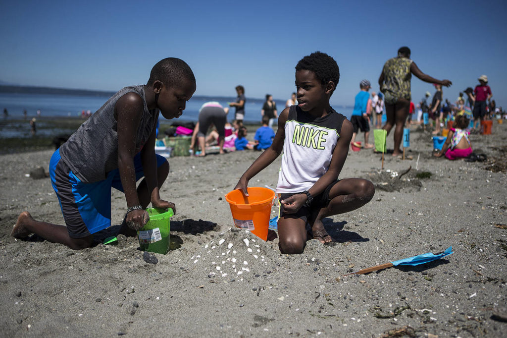 Friends John Thaiya (left), 8, and Edward Misomali, 9, build a volcano out of sand and sea shells during the annual Edmonds Sand Sculpting Contest held at Marina Beach on Tuesday. (Ian Terry / The Herald)
