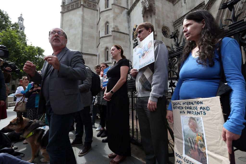 Reverend Patrick Mahoney from Washington DC, foreground left, speaks to the media outside the Royal Courts of Justice in London, as he joins other Charlie Gard supporters, Sunday July 23, 2017. Protesters who want critically ill British baby Charlie Gard to receive an experimental medical treatment gathered for a rally and prayer vigil Sunday, while hospital officials say emotions are running so high in the heart-breaking case they have received death threats. (Jonathan Brady/PA via AP)
