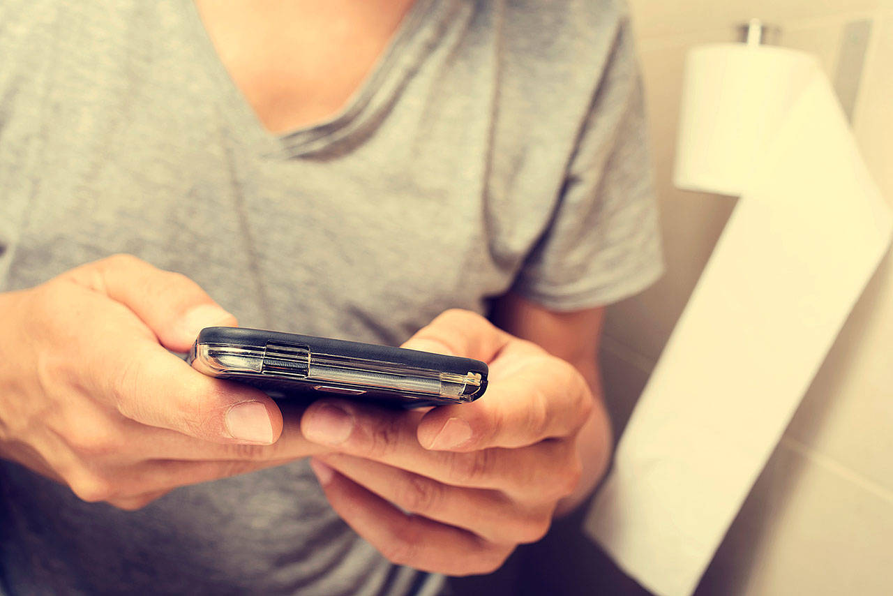 There are several reasons to put away your phone or tablet when you’re bathing, grooming or taking care of business. (Juan Moyano/Dreamstime)