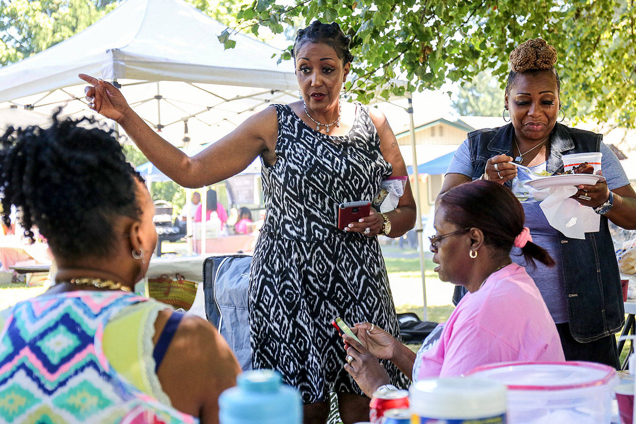 Evelyn Pearson (from left), Joy Promise, Mary Sewell and Yolanda Rochelle talk while enjoying the food, weather and music of the 25th Annual Nubian Jam at Forest Park on Saturday afternoon in Everett. (Kevin Clark / The Herald)