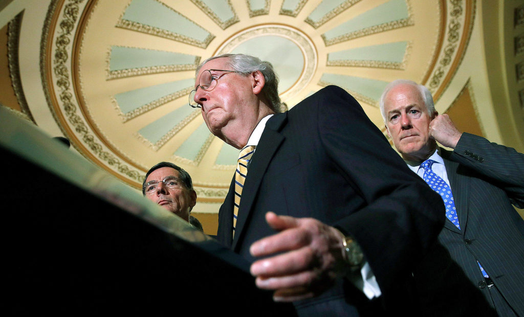 Senate Majority Leader Mitch McConnell of Kentucky (center), with Senate Majority Whip Sen. John Cornyn, R-Texas (right), and Sen. John Barrasso, R-Wyoming (left), talks to reporters on Capitol Hill in Washington on Tuesday after Vice President Mike Pence broke a 50-50 tie to start debate of Republican legislation to tear down much of the Affordable Care Act. (AP Photo/Jacquelyn Martin)
