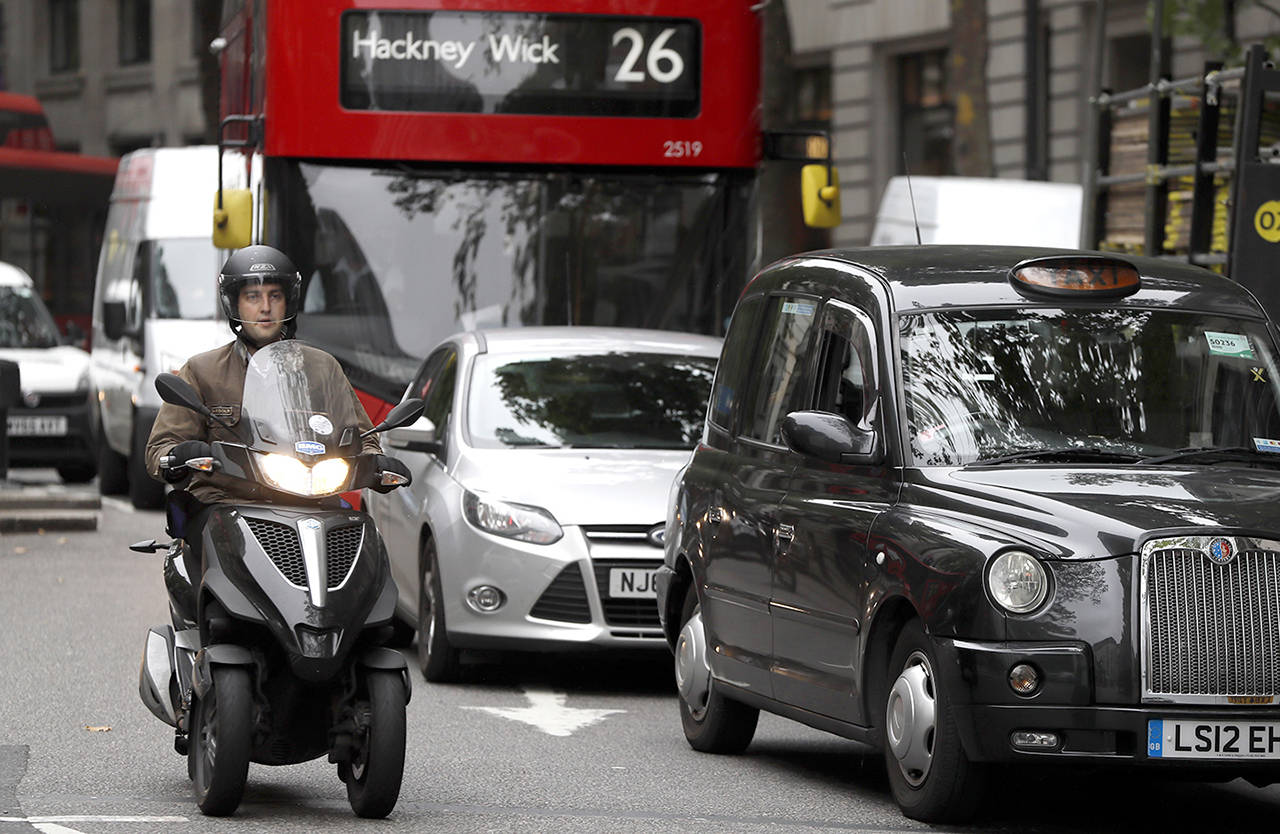 Vehicles drive in central London on Wednesday. To control air pollution, new diesel and petrol cars and vans could be banned in the UK from 2040. (AP Photo/Kirsty Wigglesworth)