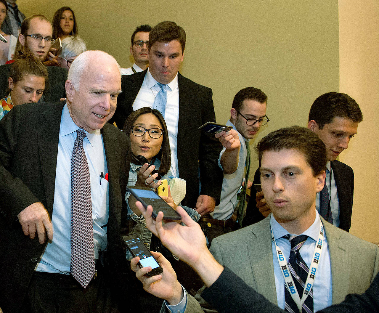 Sen. John McCain (front left), R-Arizona, is pursued by reporters on Capitol Hill in Washington early Friday after casting a “no” vote on a measure to repeal parts of Obamacare. (AP Photo/Cliff Owen)