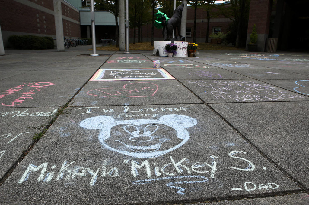 Messages and drawings written in chalk Thursday at Jackson High School commemorate the lives of three teens killed in a car crash Wednesday in Lynnwood. (Ian Terry / The Herald)
