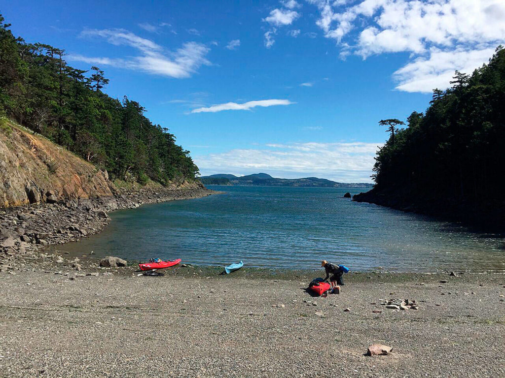 April Forgey drags her kayak up the beach at the Cypress Head landing. (Aaron Swaney / For The Herald)
