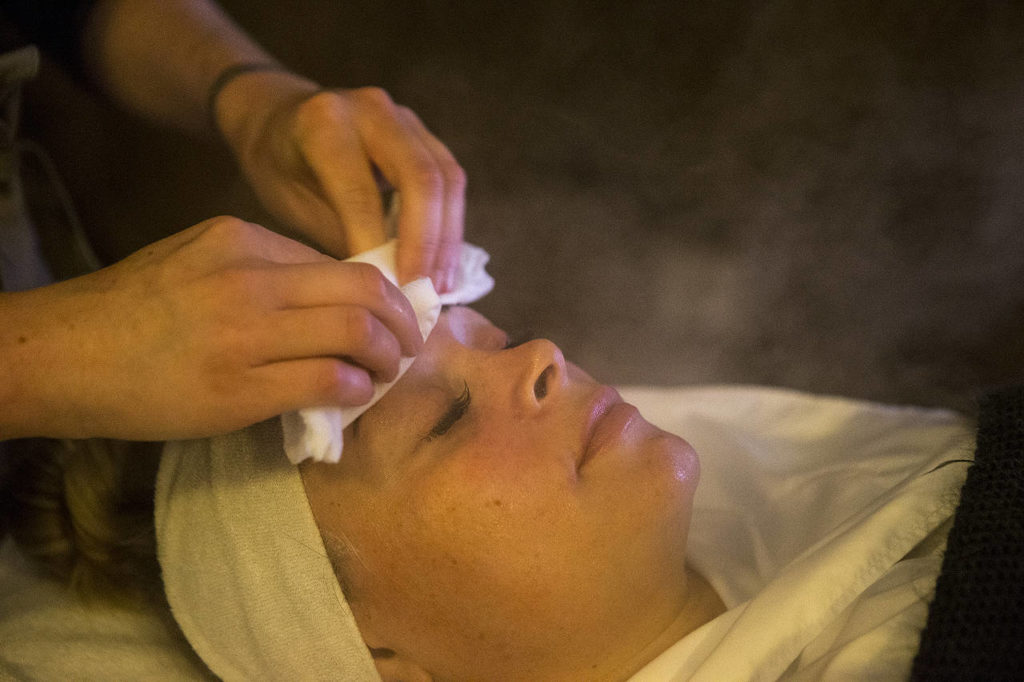 Hot steam is used on client Brieann Kadiric’s face to open up skin pores at Everett’s Grove & Kane skin clinic June 16. (Ian Terry / The Herald)
