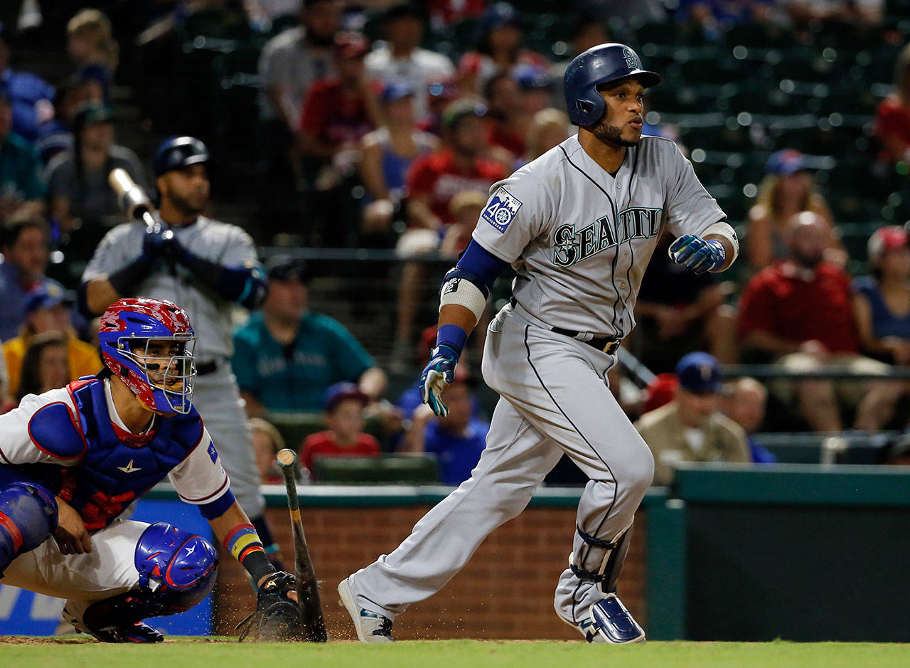 Rangers’ catcher Robinson Chirinos (left) and Mariners’ Robinson Cano (right) watch Cano’s two-run single in the ninth inning of a Monday’s game in Arlington, Texas. (AP Photo/Tony Gutierrez)