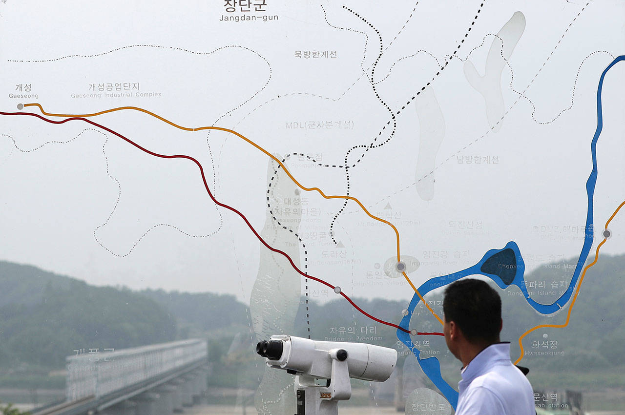 A man looks into North Korea through a glass map of the border area between North and South Koreas on Thursday at the Imjingak Pavilion near the Panmunjom, which has separated the two Koreas since the Korean War, in Paju, South Korea. (AP Photo/Lee Jin-man)