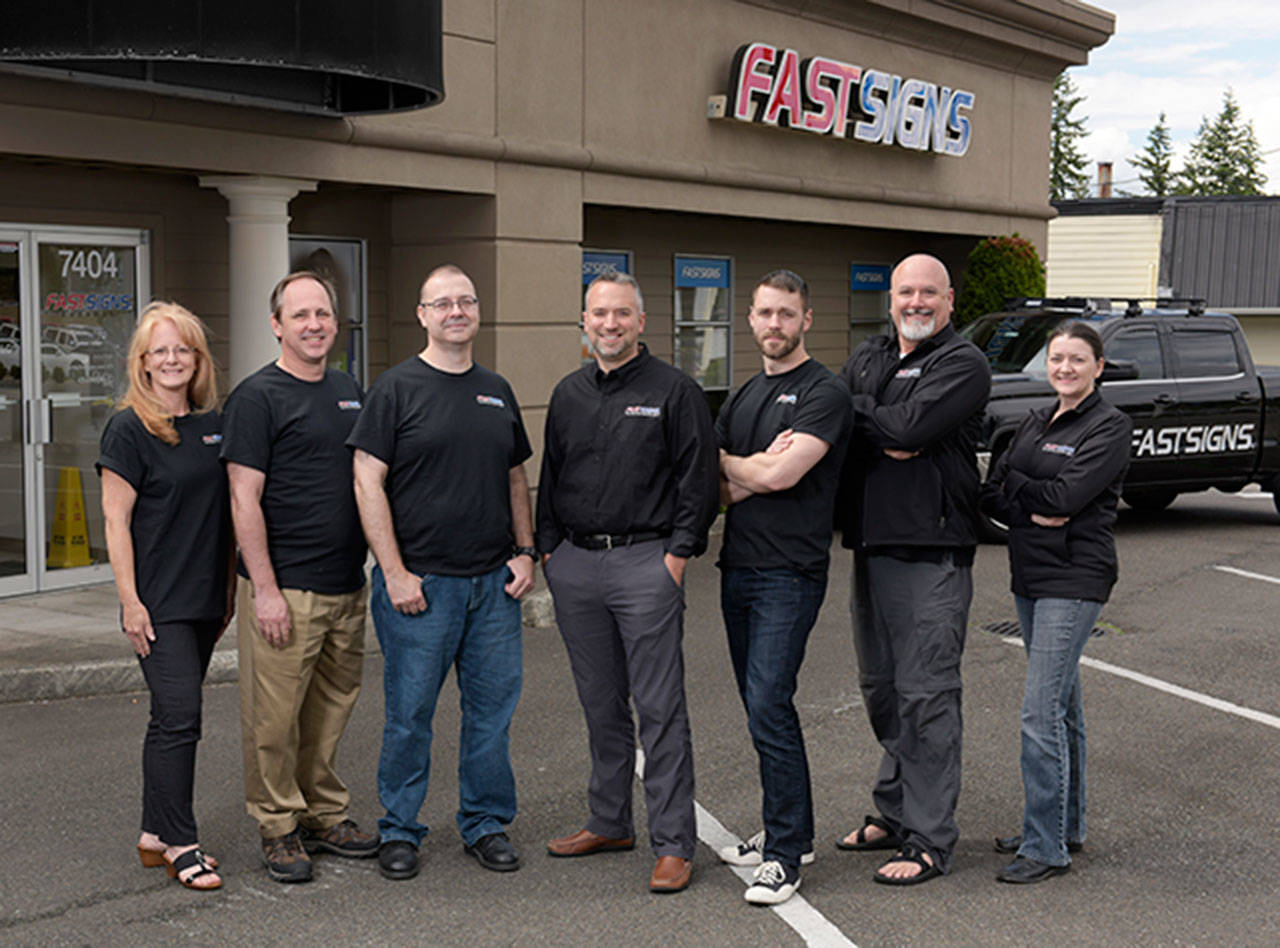 Clear Image Frame and Photo owner Daniel Jolly, center, purchased the Everett franchise of FastSigns earlier this year. He plans to move the business to downtown Everett this summer. (Contributed photo)