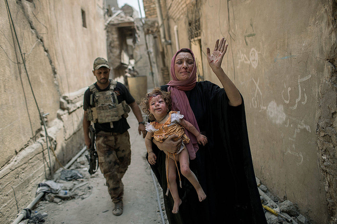 A woman holds a young injured girl as Iraqi forces continue their advance against Islamic State militants in the Old City of Mosul, Iraq, on Monday. (AP Photo/Felipe Dana)