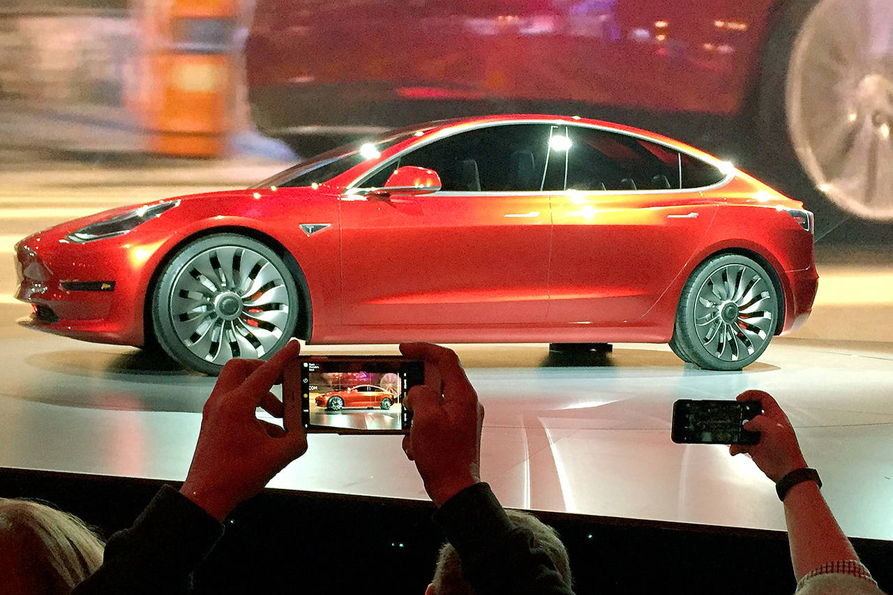 Tesla Motors unveils the new lower-priced Model 3 sedan at the Tesla Motors design studio in Hawthorne, California, in March. (AP Photo/Justin Pritchard, File)