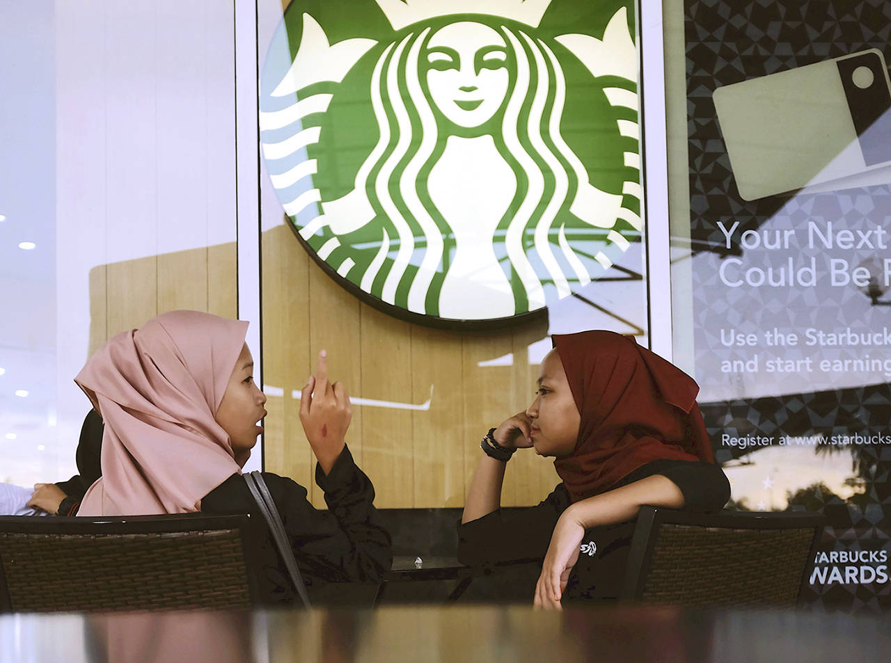 Malaysian Muslim women chat at Starbucks Coffee shop in Rawang outside Kuala Lumpur, Malaysia, on Thursday. (AP Photo/Daniel Chan)