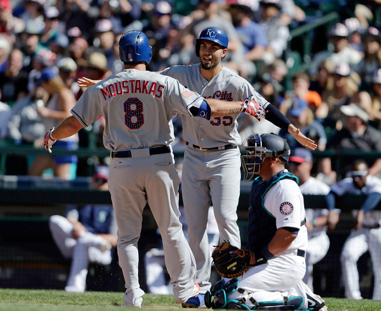 The Royals’ Mike Moustakas is greeted at home by Eric Hosmer after hitting a home run during the fourth inning of a game July 4, 2017, in Seattle. Mariners catcher Carlos Ruiz kneels on the ground. (AP Photo/John Froschauer)
