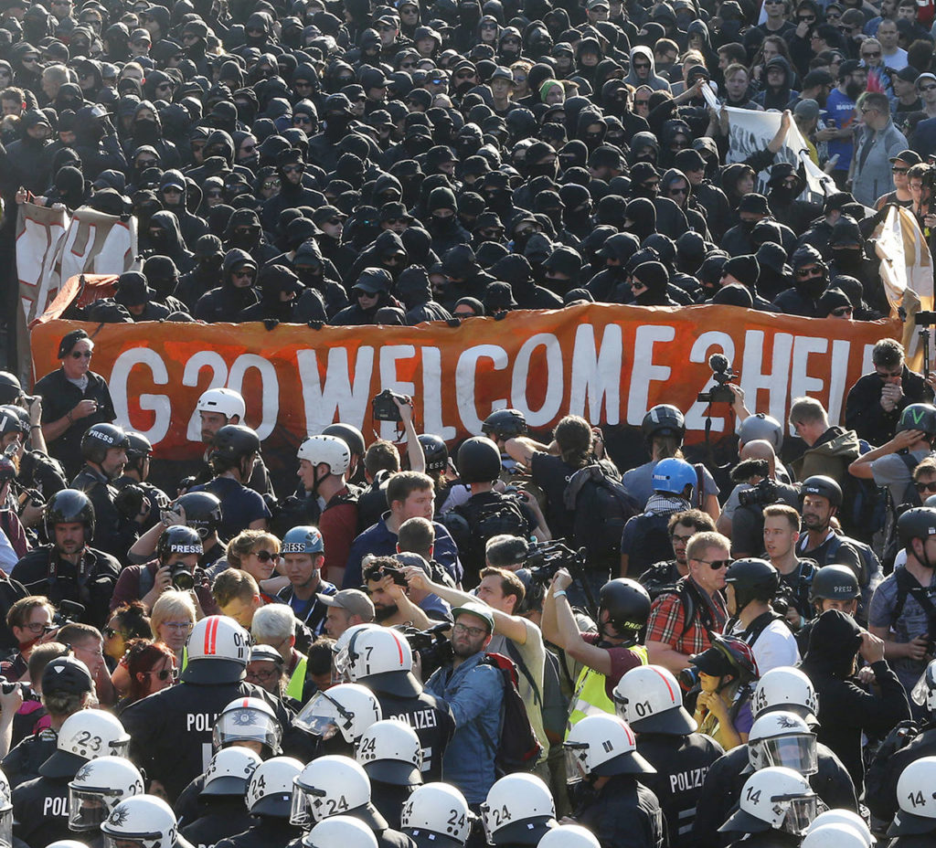 Black dressed demonstrators and police face each other during a protest titled “G20 Welcome to hell” against the G-20 summit in Hamburg, northern Germany on Thursday. (AP Photo/Michael Probst)
