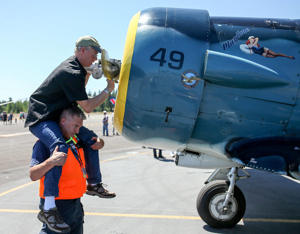 George Slocum atop Brandon Edwards’ shoulders wipe down a propellor during AFI 2017 Saturday afternoon at Arlington Municipal Airport in Arlington on July 8, 2017. (Kevin Clark / The Herald)
