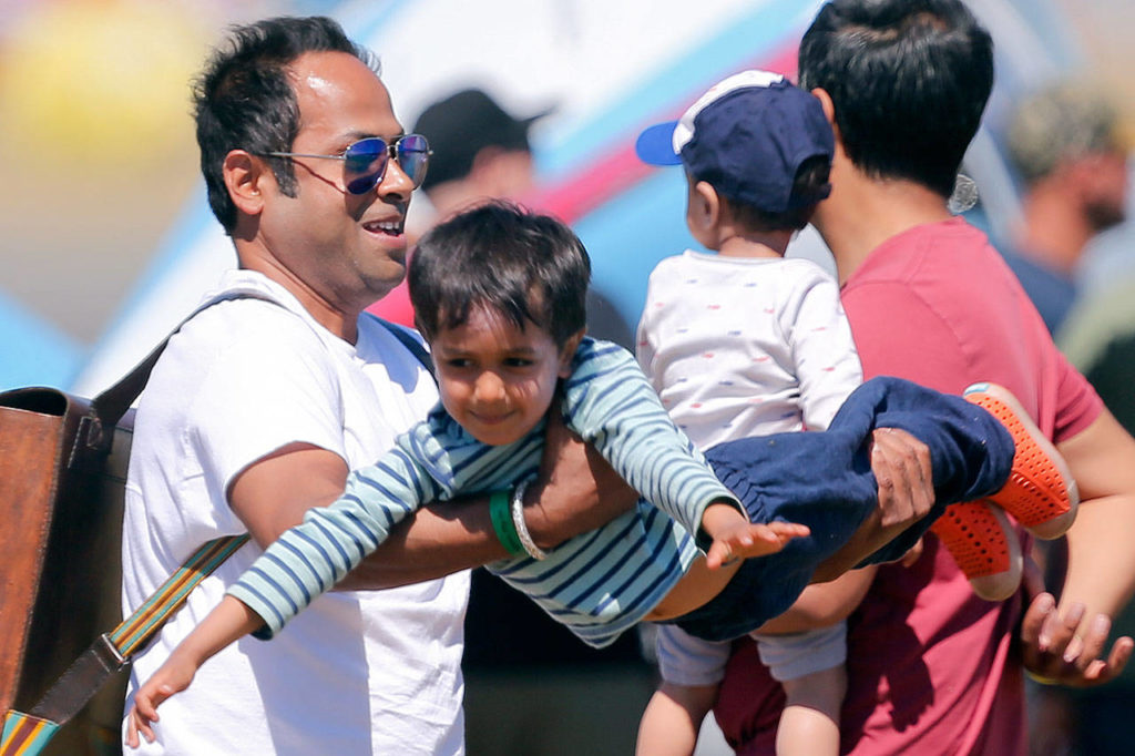 Akshyat Mathur, swings around his nephew, Vinayak Mathur, during AFI 2017 Saturday afternoon at Arlington Municipal Airport in Arlington on July 8, 2017. (Kevin Clark / The Herald)
