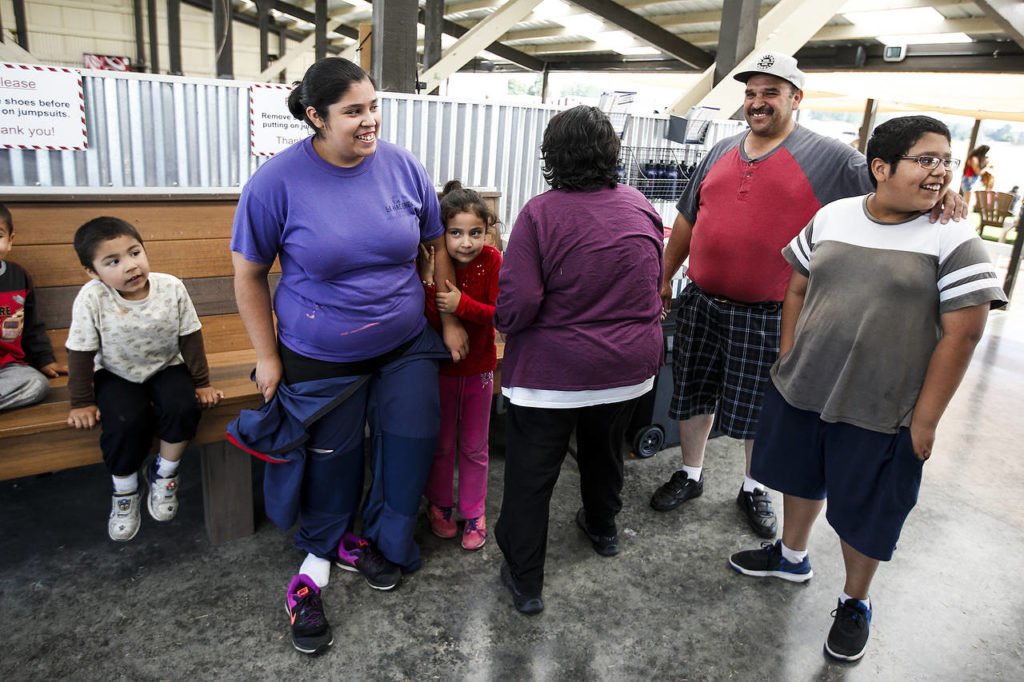 Yessica Ramos (left) is greeted by her family after skydiving at Skydive Snohomish’s Fill the Sky with Hope event on Saturday, July 1. (Ian Terry / The Herald)
