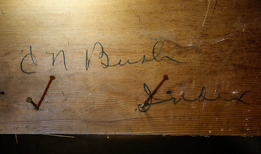 Blair Corson found the signature of Clarence Bush, the original owner of Bush House, when he removed a covering on the lower underside of a hotel staircase. (Dan Bates / The Herald)
