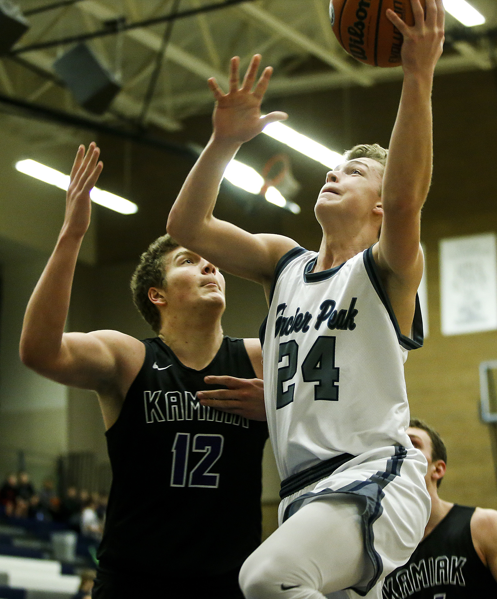 Glacier Peak’s Evan Mannes (24) goes up for a shot as Kamiak’s Landon Overtuff defends during a game Tuesday at Glacier Peak High School in Snohomish. Glacier Peak went on to defeat Kamiak 62-48. (Ian Terry / The Herald)