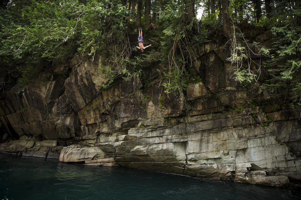 Wade Anderson, of Edmonds, backflips from a 55-foot perch at Eagle Falls near Index on Saturday, Aug. 5. (Ian Terry / The Herald)
