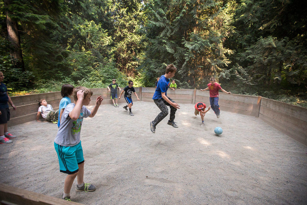 Campers leap to avoid being hit by the ball as they play Gaga, a version of dodgeball, at Camp Killoqua on Aug. 2 in Stanwood. Campers rotate through various activities such as human foosball, low and high ropes, archery and more during the week-long camp. (Andy Bronson / The Herald)
