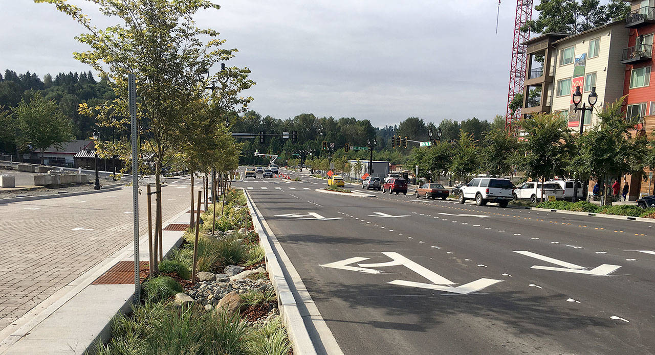 Construction crews continue to put the final touches on a new multiway boulevard in downtown Bothell. Pictured are the northbound lanes of the reshaped Bothell Way NE, between NE 183rd and NE 185th streets. The northbound, brick-lined access lane can be seen to the left of the tree-lined median. Arterial lanes with directional arrows are pictured to the right of the median. The existing southbound access lane, at far right, has been open to traffic since 2014 and features parking for local retail businesses and restaurants. (City of Bothell photo)