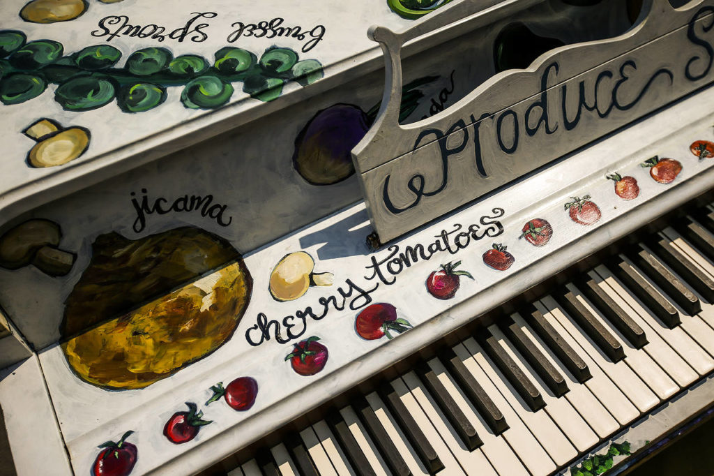 A piano painted by artist Elizabeth Person titled “Produce Sounds” is seen outside of Sno-Isle Co-Op on Grand Avenue in Everett on Wednesday, Aug. 2. (Ian Terry / The Herald)
