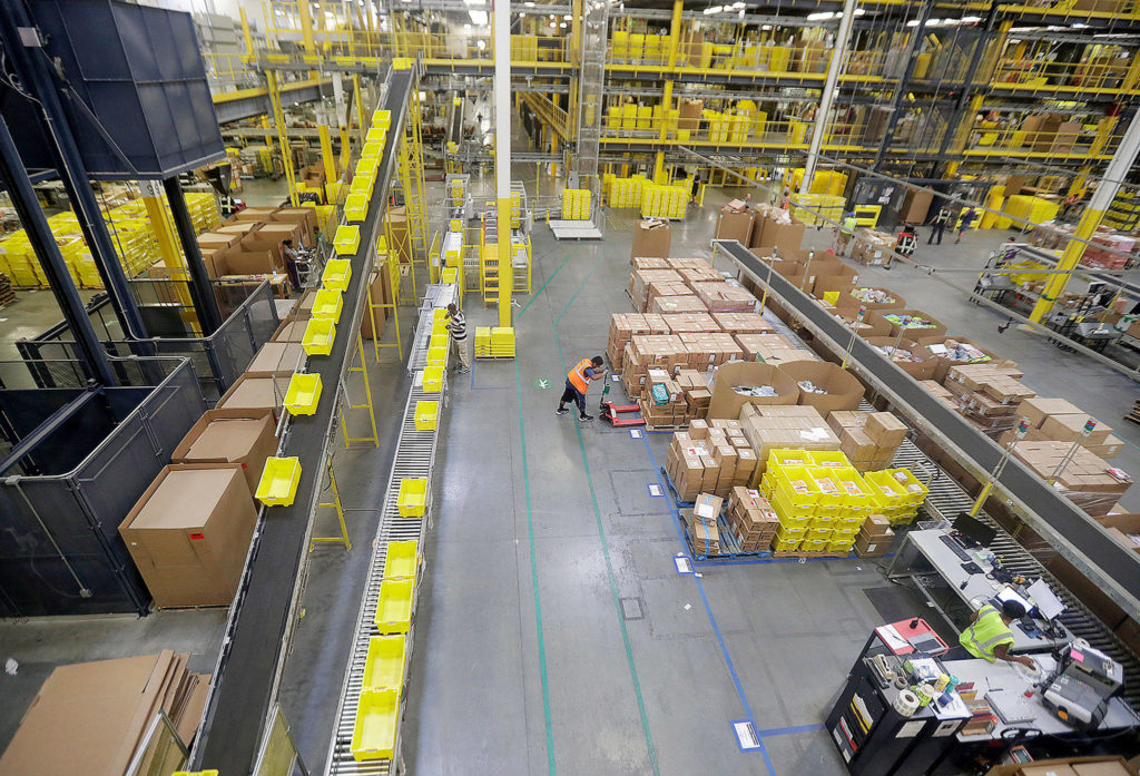 Employees work at the Amazon fulfillment center in Robbinsville Township, New Jersey. Amazon is holding a giant job fair Wednesday and plans to make thousands of job offers on the spot at nearly a dozen U.S. warehouses. (AP Photo/Julio Cortez) 
