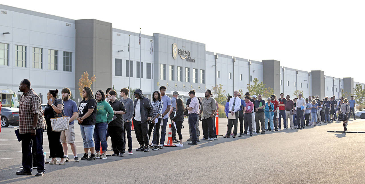 Applicants wait in line to enter a job fair Wednesday at an Amazon fulfillment center in Kent. (AP Photo/Elaine Thompson)