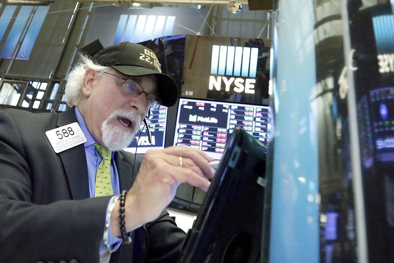 Trader Peter Tuchman wears a “Dow 22,000” hat as he works on the floor of the New York Stock Exchange on Wednesday. (AP Photo/Richard Drew)