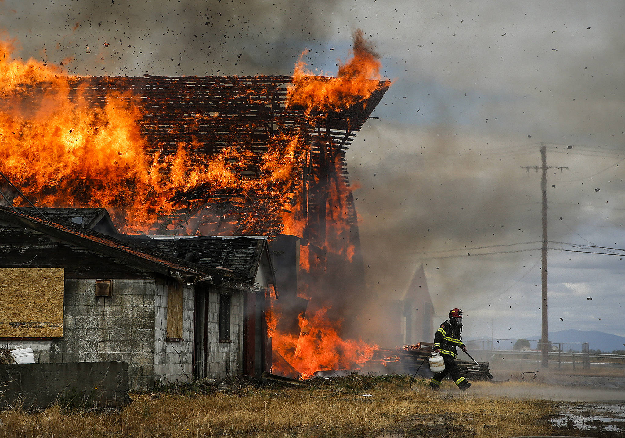 A barn burns on the Ovenell property in Stanwood on Friday, Aug. 18. The barn was deemed too unstable to be included in the city’s plans for a new park on the land so local fire departments burned it down as a training exercise. (Ian Terry / The Herald)
