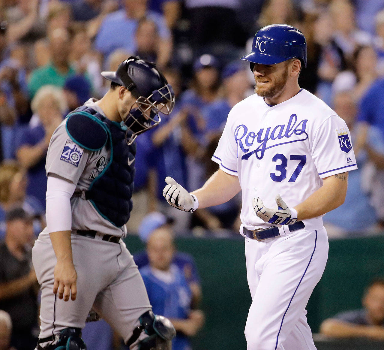 The Royals’ Brandon Moss (37) crosses the plate past Mariners catcher Mike Zunino after hitting a two-run home run during the fifth inning of a game Aug. 3, 2017, in Kansas City, Mo. (AP Photo/Charlie Riedel)