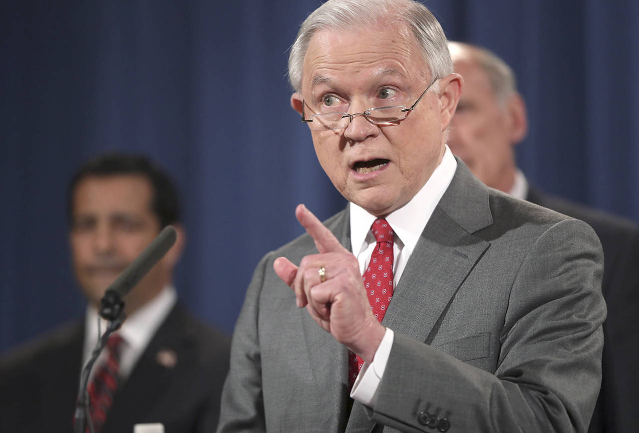 Attorney General Jeff Sessions, accompanied by (from left) National Counterintelligence and Security Center Director William Evanina and Director of National Intelligence Dan Coats, speaks during a news conference at the Justice Department in Washington on Friday. (AP Andrew Harnik)