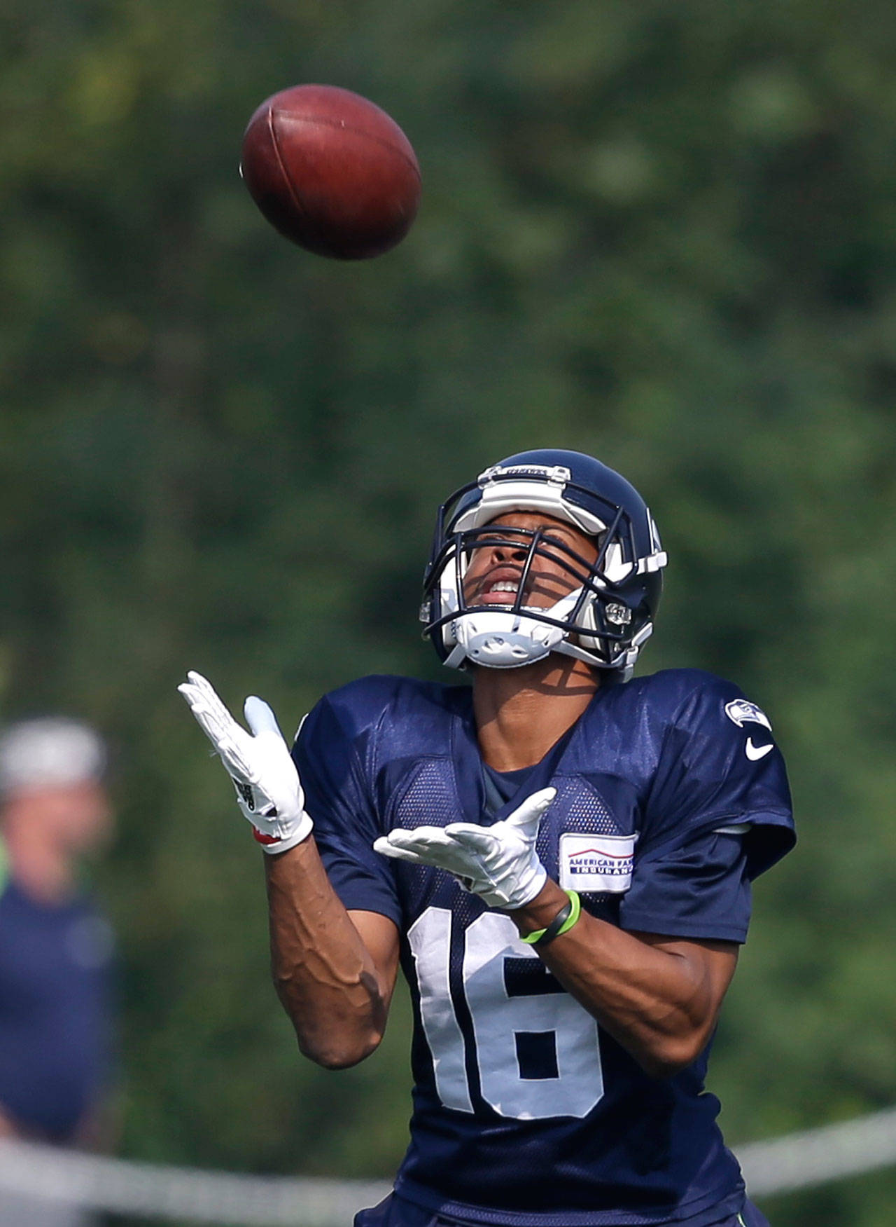 Seattle’s Tyler Lockett reaches to catch a ball Friday during a training camp session in Renton. (AP Photo/Elaine Thompson)