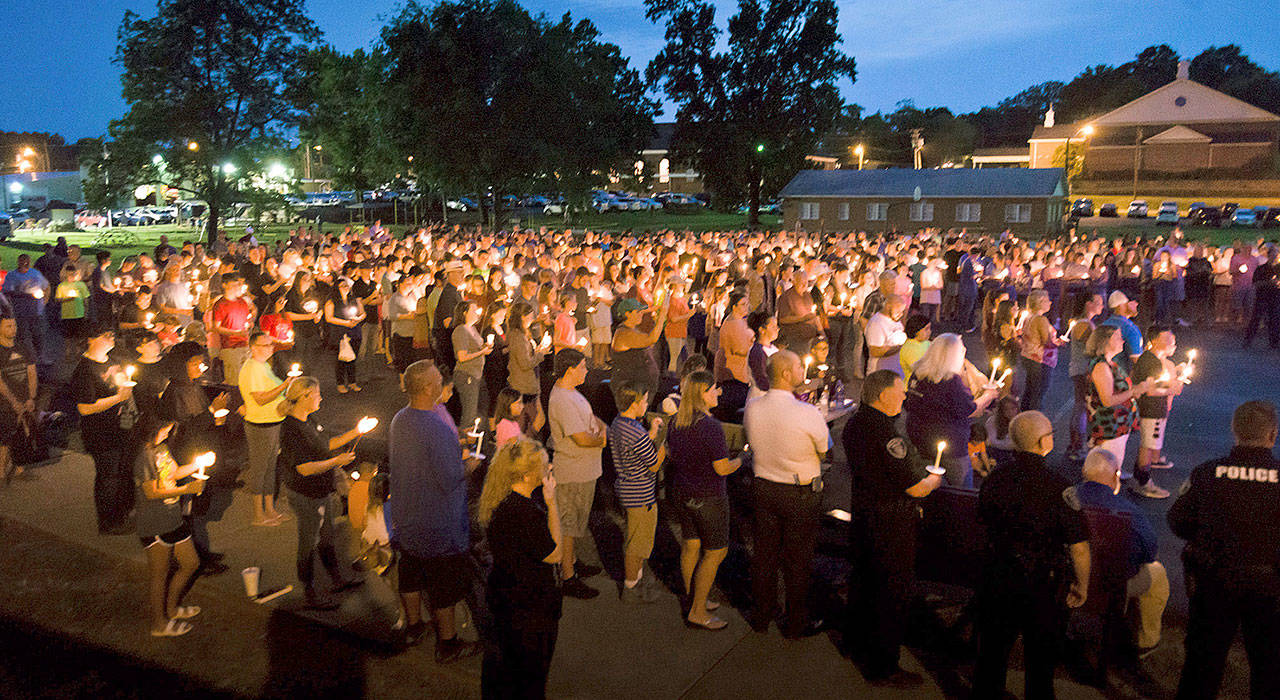 Hundreds from Hallsville, Texas, and surrounding communities gather for a candlelight vigil on Sunday after two Boy Scouts were killed and another was severely injured in a Saturday boating accident. The third boy later died. (Les Hassell/The News-Journal via AP)