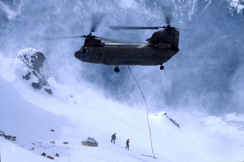 A military helicopter hovers over the slopes of Glacier Peak on June 25, 1983, as crews from Snohomish County Search and Rescue, the sheriff’s office, the U.S. Army and the National Transportation Safety Board worked for seven hours to remove the bodies of five plane crash victims. (Photo by Jim Leo, Herald photographer)

