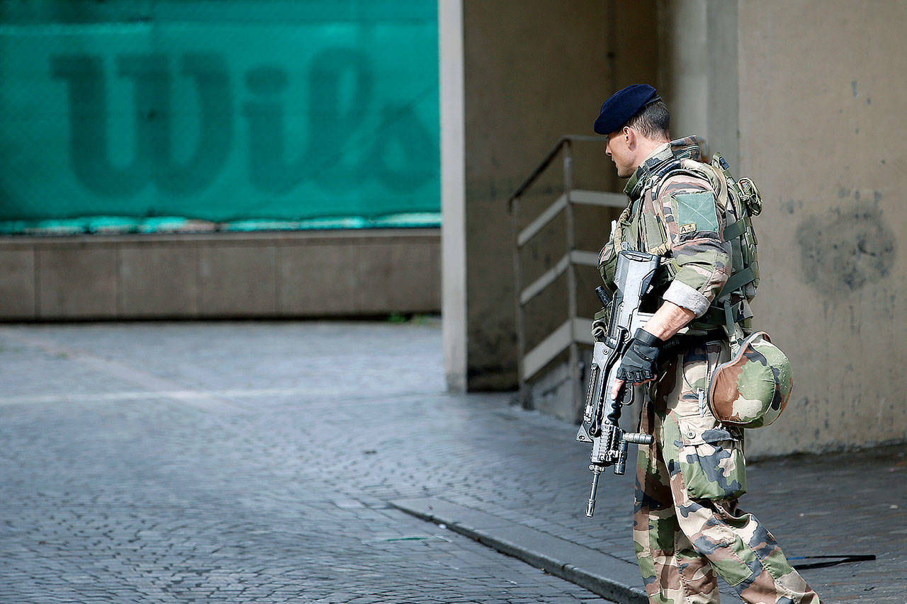 A French soldier patrols near the scene where other soldiers were hit and injured by a vehicle on Wednesday in the western Paris suburb of Levallois-Perret. (AP Photo/Kamil Zihnioglu)