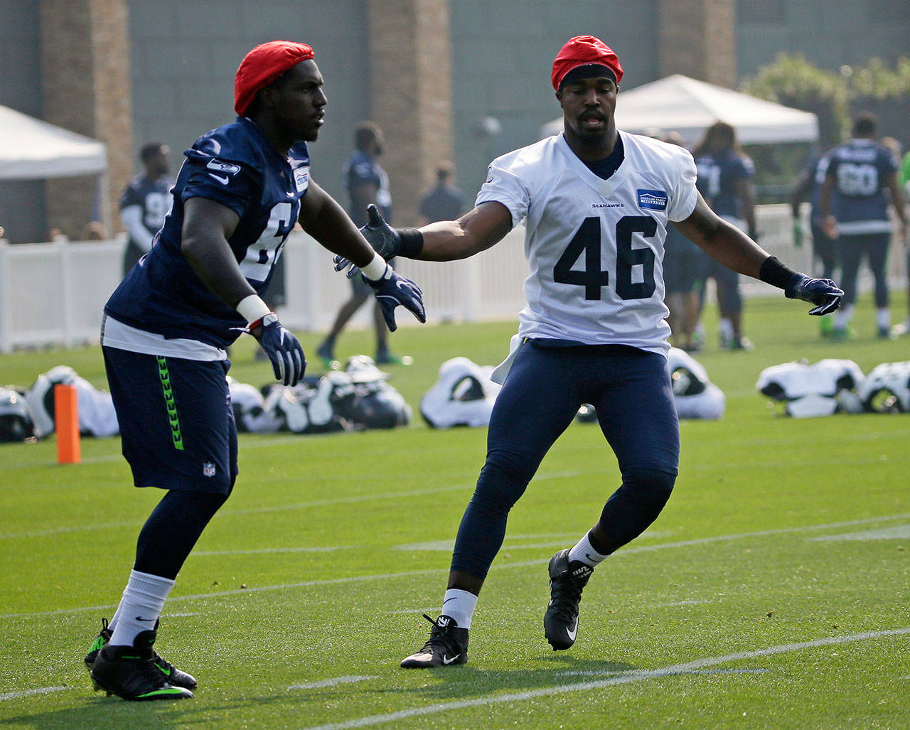 Seahawks tight end Tyrone Swoopes (46) and defensive tackle Tylor Harris (left) move together during a drill at training camp Aug. 10, 2017, in Renton. (AP Photo/Ted S. Warren)